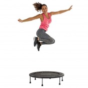 Person står på trampolin med armarna utsträckta och gör en balansövning på hoppduken.