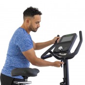 Person som tränar sittande på motionscykel med fokus på styre och överkropp