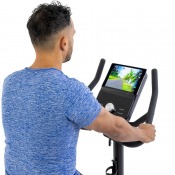 Person sedd bakifrån som använder konsolen på motionscykel och interagerar med displayen
