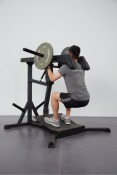 Användare som demonstrerar en squatövning på IFP Leverage Squat/Calf Black. Handtag och ergonomiska dynor erbjuder en stabil och