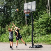Court Champ basketkorg utomhus under spel på uppfart