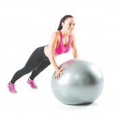 Gymboll i silver använd av person i träningskläder i ljus träningsmiljö.