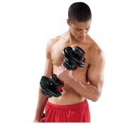 Person håller Bowflex SelectTech 552i justerbar hantel i handen, sedd i träningsmiljö.