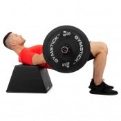 Man gör hip thrust med skivstång mot Glute Bench