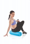Kvinna sitter och rullar benen med Gymstick Active Foam Roller 60 cm