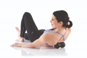 Kvinna masserar nacken liggande på Gymstick Active Recovery Twin Ball