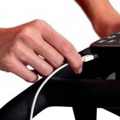 Detaljbild på hand som justerar höjdinställning under sadeln med låsmekanism i metall.