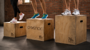Plyobox i trä som används vid hoppövning av person i träningskläder, placerad i mörk träningsmiljö.
