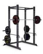Power rack med skivstång monterad på hållare och viktskivor på sidorna, mot vit bakgrund.