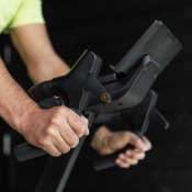 Detaljbild på händer som justerar pedalrem vid svart pedal