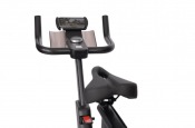 Detaljbild på styre med flera grepp och justeringsratt på spinningcykel.