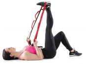 Stretching Belt som används av liggande person för benstretch, visad i inomhusmiljö med fokus på bandets öglor.