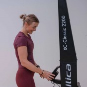 Skitrainer i användning sedd från sidan med person som drar handtagen i träningsmiljö.