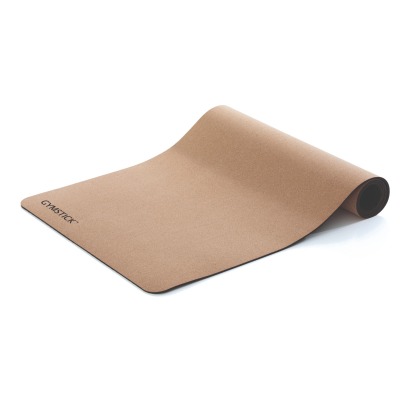 Yogamatta i kork med utrullad form och mörk undersida på vit bakgrund.